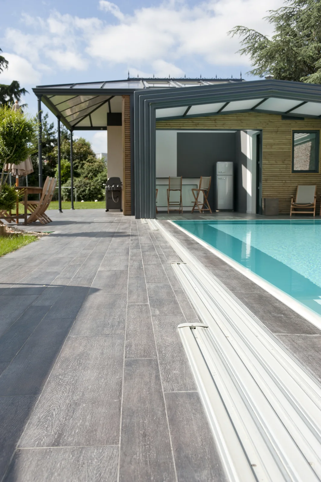 Abri de piscine adossé longeant un bassin rectangulaire