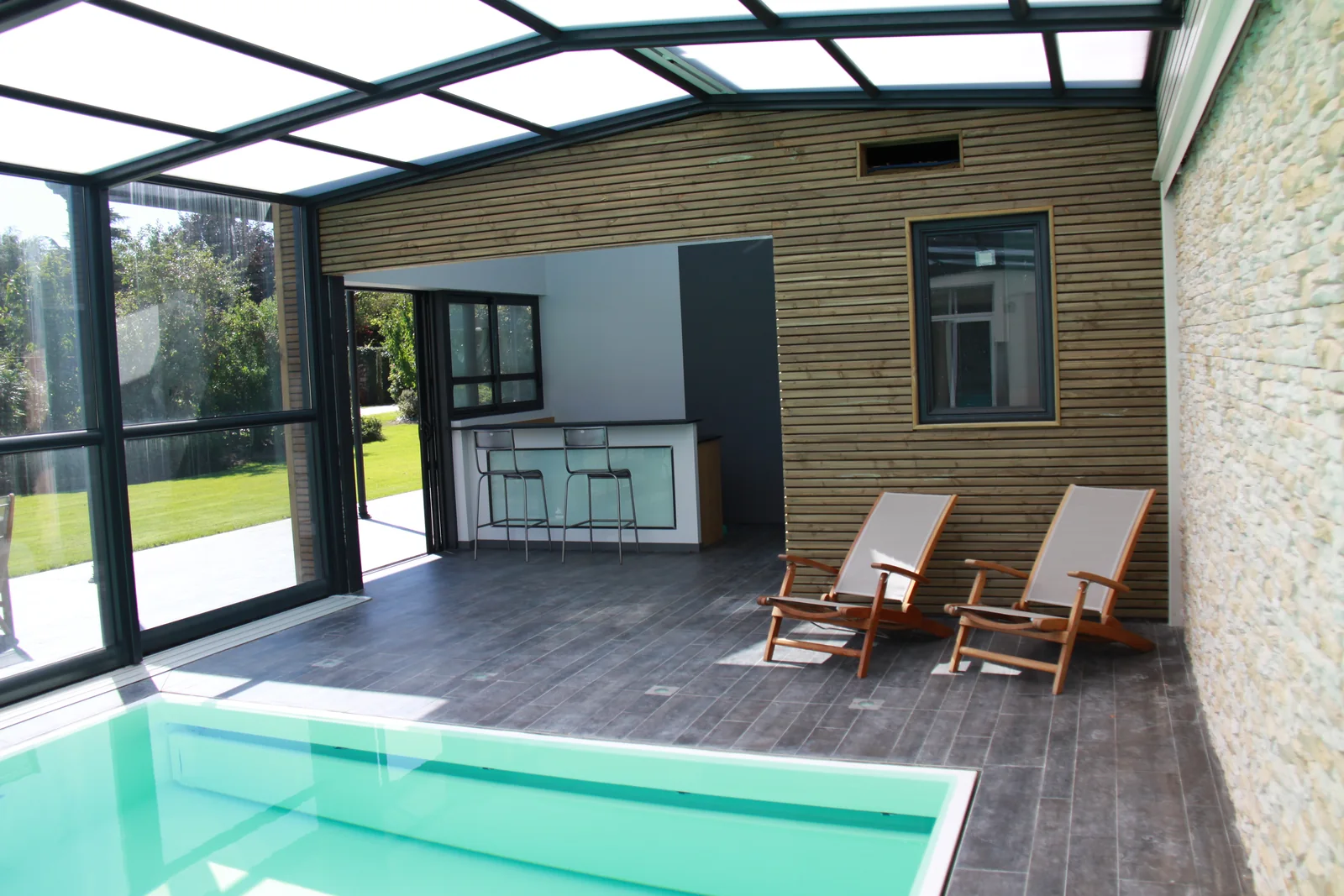 Abri de piscine adossé avec terrasse couverte au bord du bassin