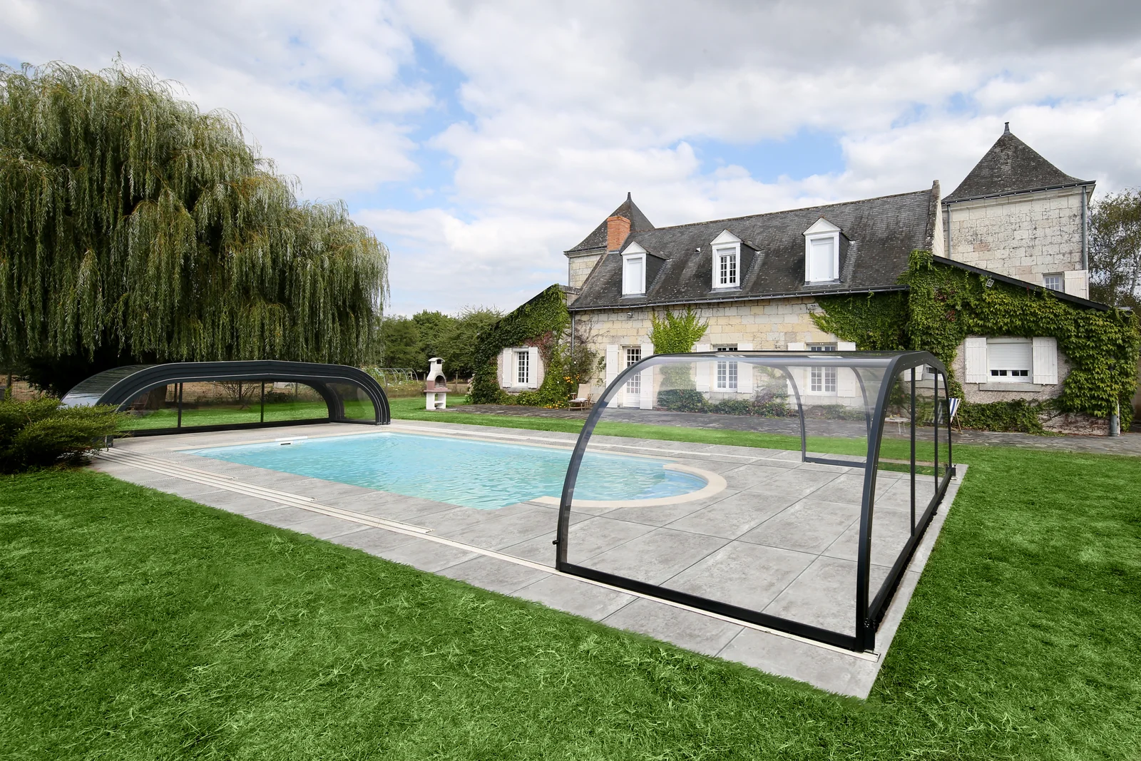 Abri de piscine bas vu de face dans un jardin paysager