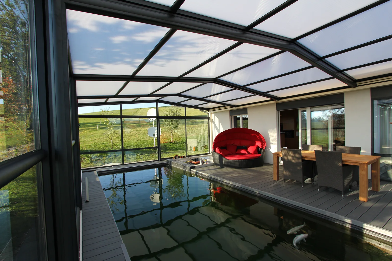 Vue intérieure d’un abri de piscine haut avec espace de détente