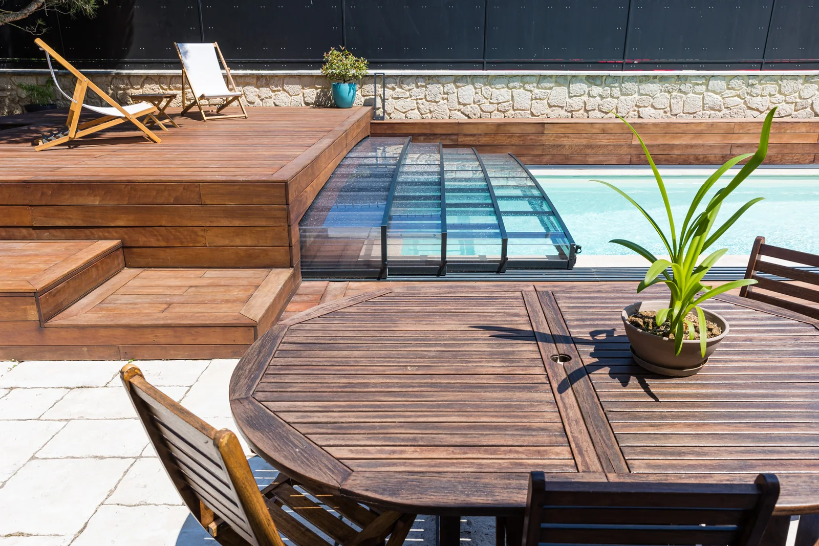 Abri de piscine semi-plat intégré à une terrasse en bois