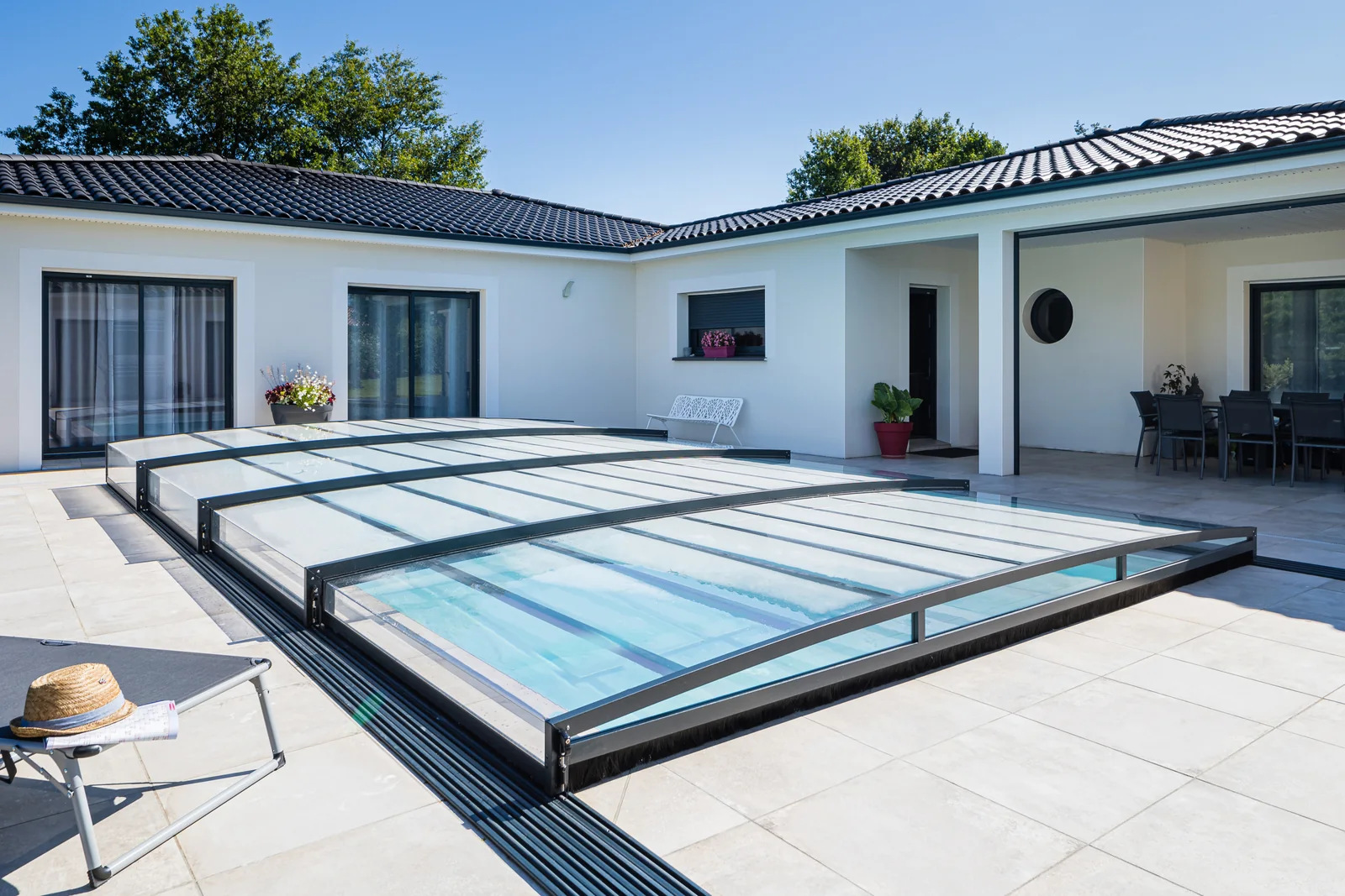 Abri de piscine semi-plat fermé devant une maison contemporaine