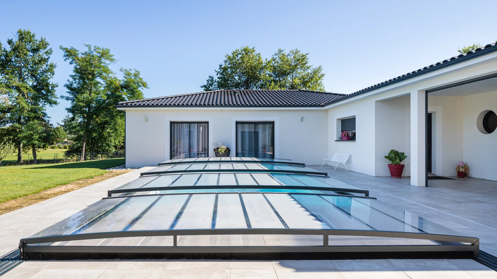 Abri de piscine semi-plat ouvert le long d’une terrasse claire