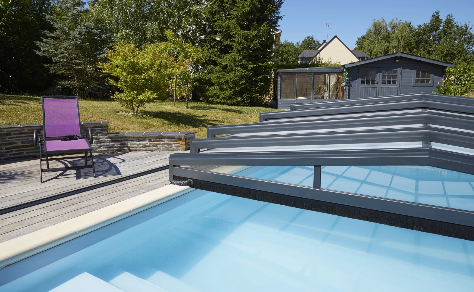 Modules télescopiques d’un abri de piscine regroupés près d’un escalier